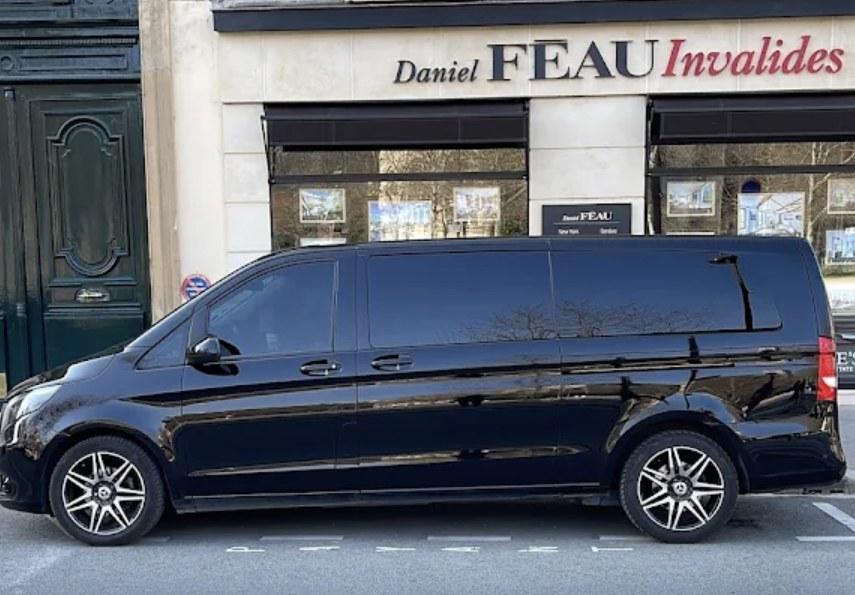 Le van Mercedes-Benz noir vu de profil, à l’arrêt le long d’une façade haussmannienne parisienne